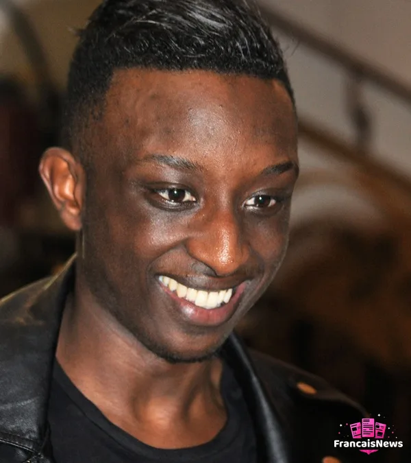 ahmed sylla sur scène au Petit Palais des Glaces, en plein spectacle d'humour