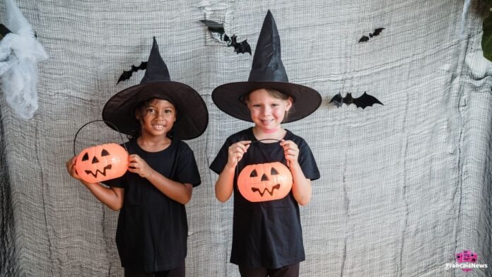 Deux petites filles en déguisement Halloween de sorcières tenant des seaux citrouilles