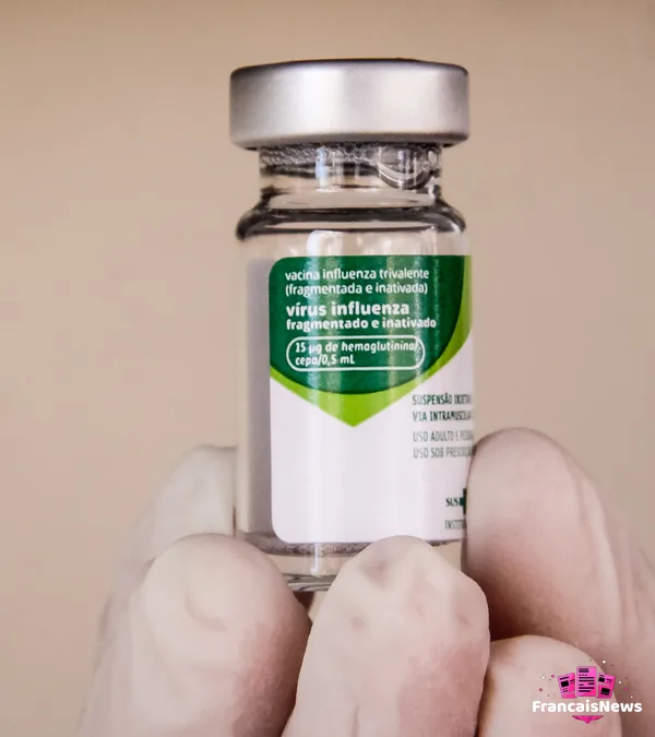 vaccination grippe 2026 : un flacon de vaccin contre le virus influenza tenu par une main gantée